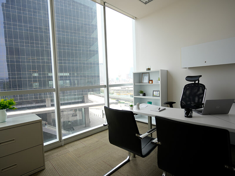 Oficina privada vacía con escritorio y silla junto a ventanal – Iza Office Club