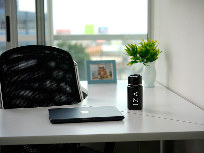 Escritorio con laptop, silla negra y marco de fotos – Iza Office Club