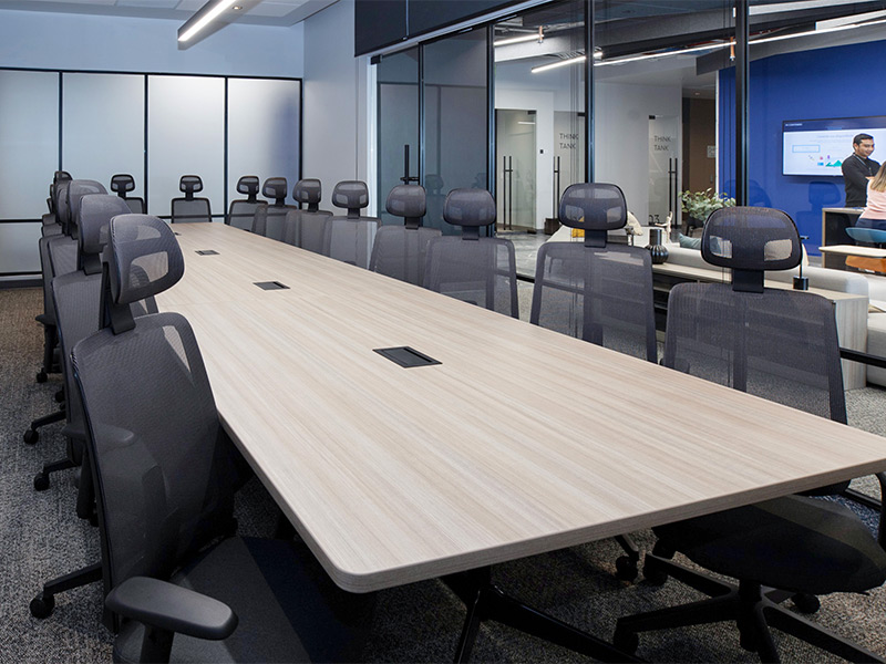 Amplia sala de juntas corporativa con mesa larga de madera clara y sillas ergonómicas modernas en Inxignia, oficina en renta en Puebla