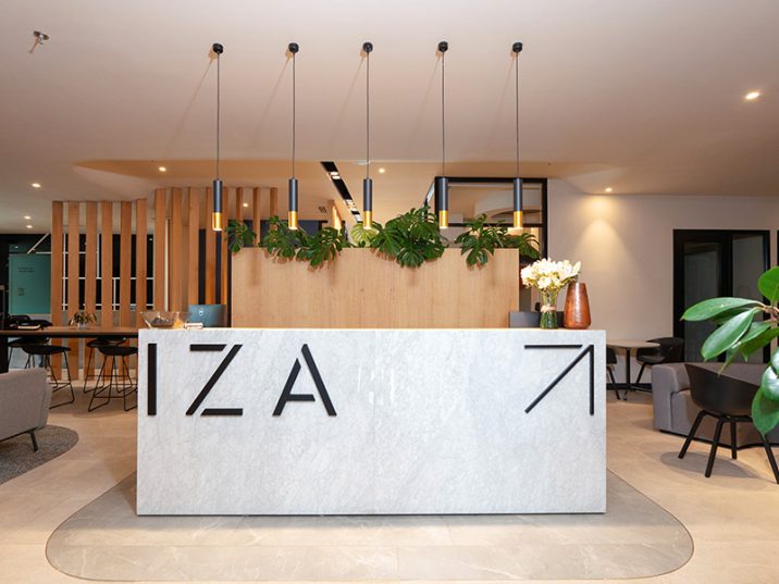 Recepción principal de IZA Business Center con mostrador de mármol y logo destacado en Punto Sao Paulo, oficina en renta en Guadalajara