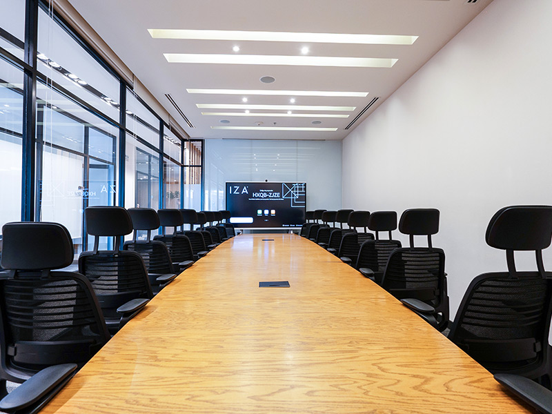 Amplia sala de juntas IZA con mesa larga y pantalla interactiva para presentaciones en Punto Sao Paulo, oficina en renta en Guadalajara