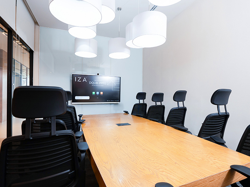 Sala de juntas IZA con mesa grande, sillas ejecutivas y lámparas conectadas al techo de color blanco en Punto Sao Paulo, oficina en renta en Guadalajara