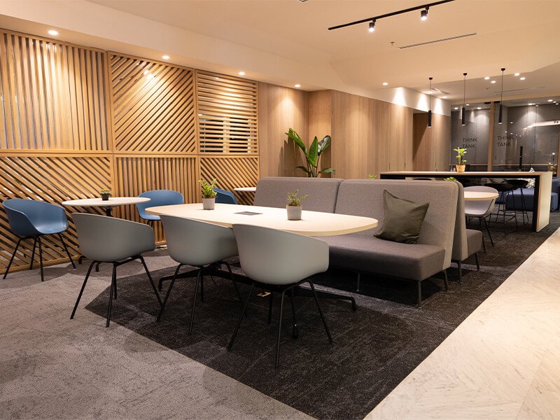 Sala de lounge con sillones grises y mesa de centro – Iza Office Club
