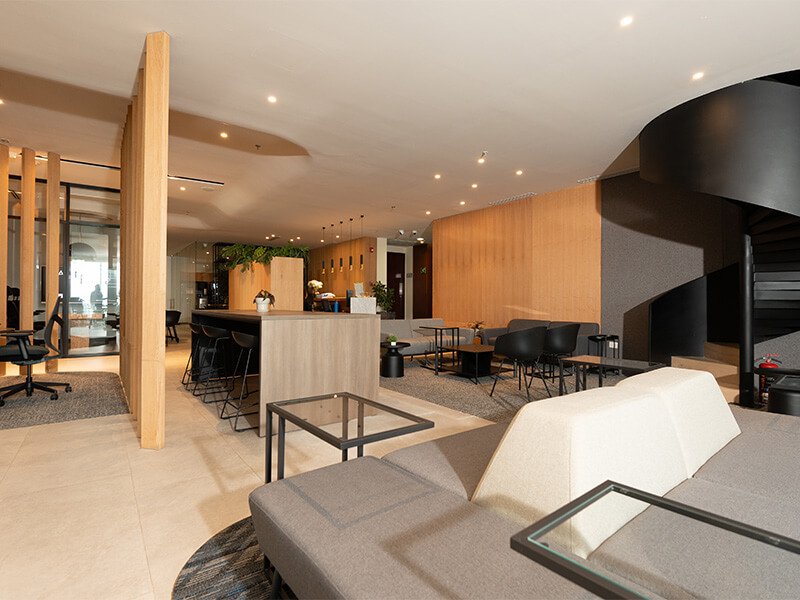 Sala de estar con sillón blanco curvo y lámpara de madera – Iza Office Club