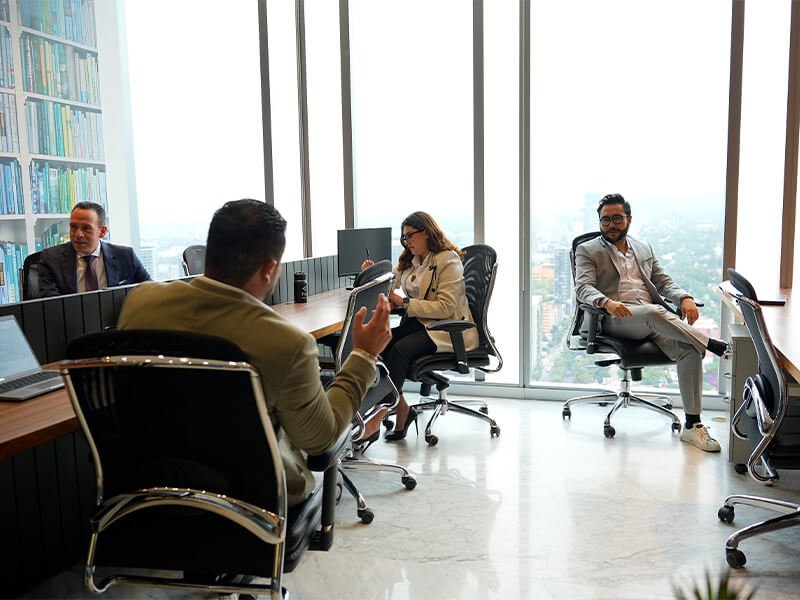 Personas trabajando en sala de juntas de vidrio – Iza Office Club